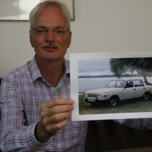 Olaf Damm mit einem Foto des hellblauen Wartburg.